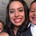 Erika Serrano, a latina and staff member of Center for Health Progress, poses for a selfie with her two young sons, all dressed up to go to a quincinera